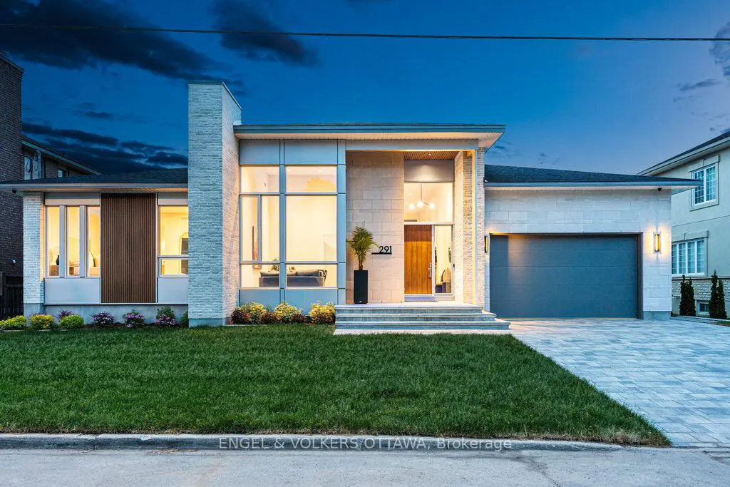 Exterior shot of a modern, single-story home with a gray garage door, stone facade, and large windows under a twilight sky.
