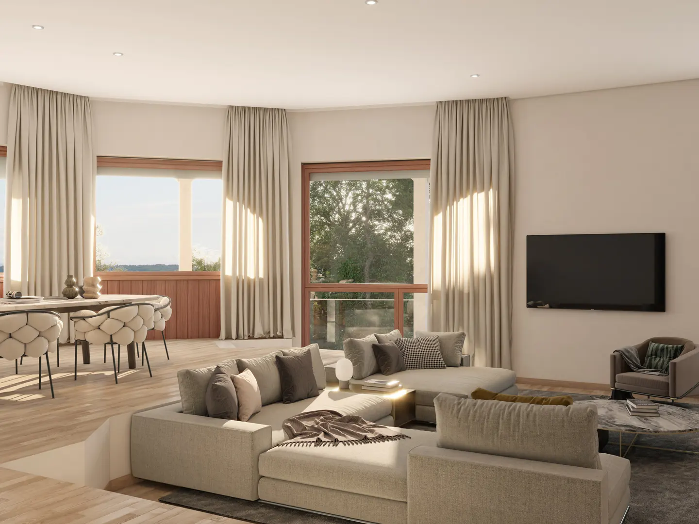 A bright, modern living room with beige sofas, a dining table with unique chairs, and large windows with curtains. A TV is mounted on the wall.