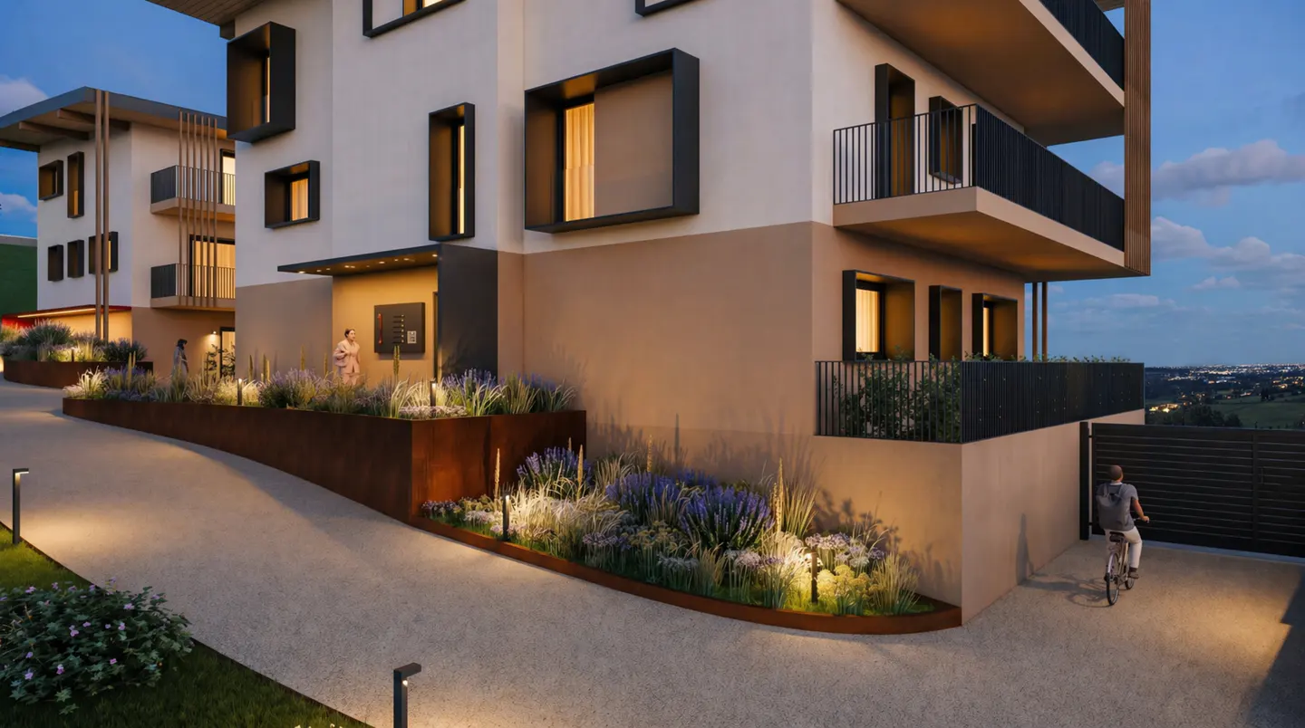 Modern apartment building exterior at dusk with a cyclist on the driveway. The building is two-toned, with black window frames and balcony railings.