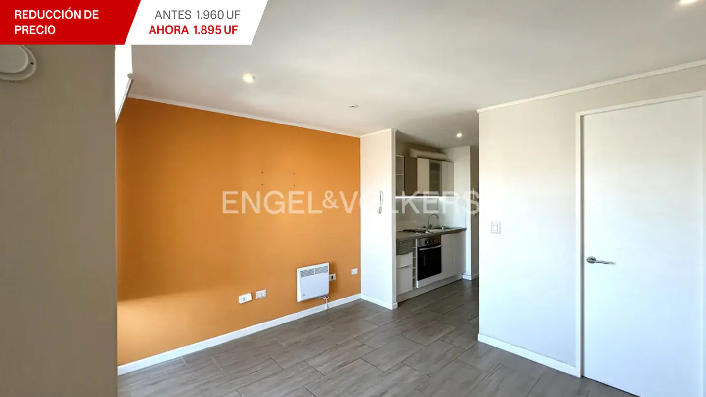 A bright apartment interior with orange wall, small kitchen, and white door. Engel & Volkers logo is visible.